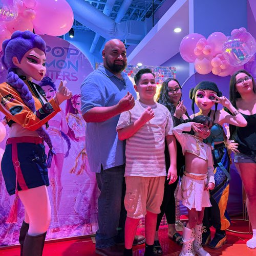 Family celebrating a birthday party with costumed characters at Candeeland El Centro